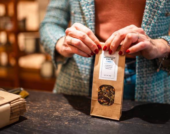 Hands holding brown paper tea package