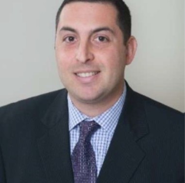 Smiling professional headshot of man in suit
