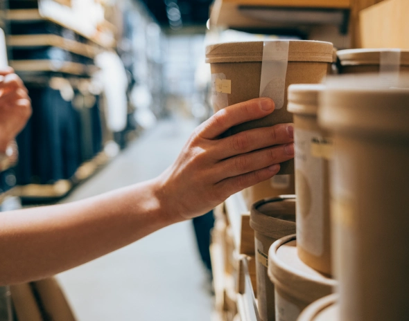 Hand picking eco-friendly cardboard containers from shelf